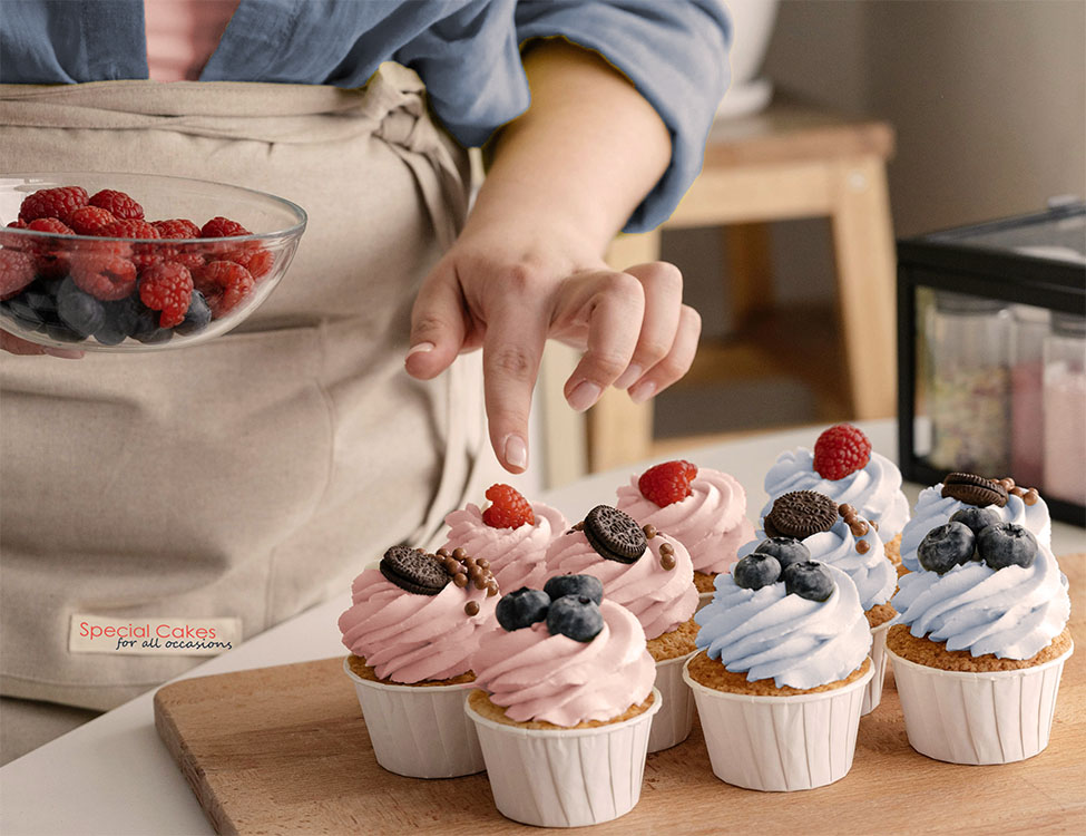 Baker decorating cupcakes with small fruits